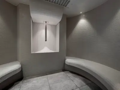 Moderner Eisraum im MSC Aurea Spa der MSC Grandiosa. Helle Fliesen, geschwungene Bänke und ein Schneespender mit Eis bieten Abkühlung.