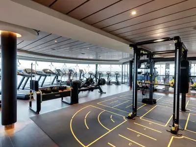 Das moderne Fitnessstudio an Bord der MSC Grandiosa bietet einen Panoramablick. Ausgestattet mit Laufbändern, Rudergeräten und einem Krafttrainingsbereich mit Gewichten.