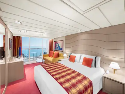 Moderne Junior Suite Aurea Balkonkabine an Bord der MSC Lirica mit Doppelbett, gelbem Sofa und Meerblick. Der Raum ist in warmen Rot- und Gelbtönen eingerichtet und wirkt einladend.