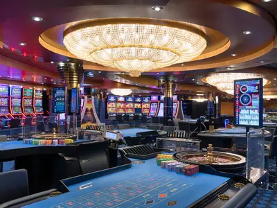 Blick in das elegant beleuchtete Atlantic City Casino an Bord der MSC Magnifica. Mehrere Spielautomaten, leere Roulette-Tische mit bunten Chips und digitalen Anzeigen sind sichtbar.