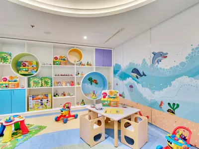 Der bunte Kinderbereich an Bord der MSC Meraviglia zeigt eine Spielzone mit Tischen, Stühlen, Regalen voller Spielzeug und einer Wandmalerei mit Meeresmotiven wie Delfinen und Walen.