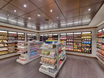 Blick in die Mini Mall an Bord der MSC Meraviglia, gefuellt mit Regalen voller Schokolade, Snacks und Suessigkeiten unter heller Beleuchtung.