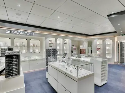Eine helle Innenansicht des Swarovski Shops an Bord der MSC Meraviglia. Zahlreiche Vitrinen präsentieren Schmuckstücke und Accessoires unter heller Deckenbeleuchtung.