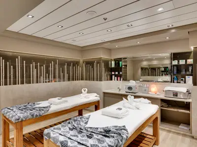 Zwei Massageliegen im hellen Behandlungsraum des MSC Aurea Spa an Bord der MSC Meraviglia. Moderne Spa-Geräte und Bambusmuster an den Wänden unterstreichen die ruhige Atmosphäre.