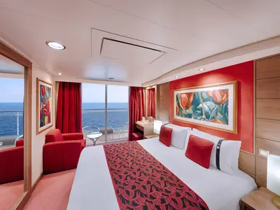 Helle Balkonkabine an Bord der MSC Musica mit Doppelbett, roten Akzenten und Zugang zum Balkon mit weitem Meerblick.