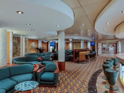 Bar della Cascata an Bord der MSC Musica mit teal-farbenen Sofas, Marmor-Bartresen und gemustertem Teppich. Einladende, luxuriöse Atmosphäre.