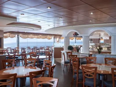 Geräumiges Buffetrestaurant an Bord der MSC Musica. Viele Tische, Stühle und Buffettheken. Große Fenster mit Meerblick. Klassisches Interieur.