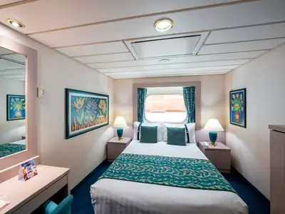 Helle und moderne Aussenkabine an Bord der MSC Opera mit Doppelbett, Bullaugenfenster und Nachttischen. Der Raum ist in Creme- und Türkistönen gestaltet.