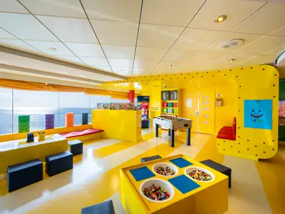 Der lebhafte Junior Club an Bord der MSC Opera, gestaltet in leuchtendem Gelb. Mit Meerblick, Tischen voller LEGO-Bausteine und einem Foosball-Tisch.