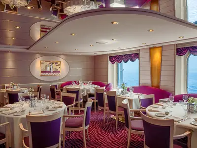 Eleganter Restaurantbereich L'Approdo an Bord der MSC Opera. Zahlreiche Tische sind gedeckt, umgeben von lila Stühlen und Sitzbänken. Große Fenster bieten einen weiten Blick auf das offene Meer.