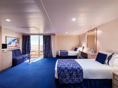 Geräumige, barrierefreie Balkonkabine an Bord der MSC Orchestra. Man sieht zwei Einzelbetten, ein Sofa, einen Schreibtisch und einen privaten Balkon. Die Kabine ist in Blau- und Beigetönen eingerichtet.