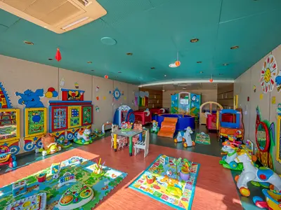 Heller Baby Club Indoor Playroom an Bord der MSC Orchestra mit Spielmatten, Rutsche, Bällebad, Schaukelpferden und bunten Tier-Wandstickern.