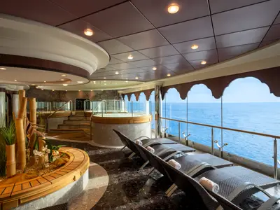 Der Thermalbereich des MSC Aurea Spa an Bord der MSC Orchestra mit Whirlpool, Liegestühlen und grossen Fenstern zum Meer. Dekoration mit Bambus und Pflanzen.