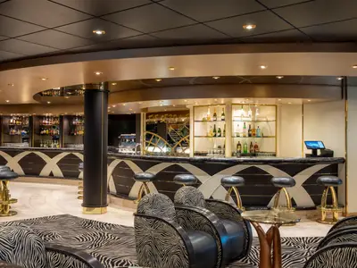 Die elegante Bar 'The Zebra Bar' an Bord der MSC Poesia zeigt eine geschwungene Theke mit dunklem Marmor, goldenen Stühlen und einer Zebra-Muster-Teppich.
