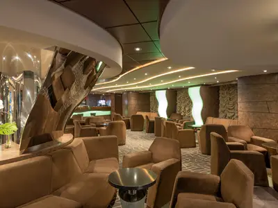 Lounge der Diamond Bar an Bord der MSC Preziosa. Viele braune Sessel, Tische, moderne Lichtinstallationen und eine Bar im Hintergrund.