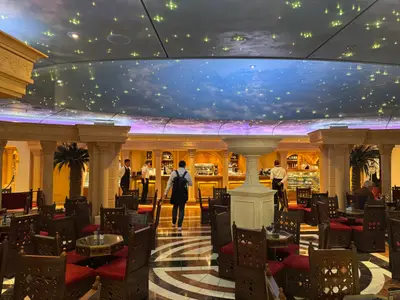 Ein prächtiges Café an Bord der MSC Preziosa mit Säulengängen, detailreichen Holzstühlen und leuchtender Sternenhimmel-Decke.