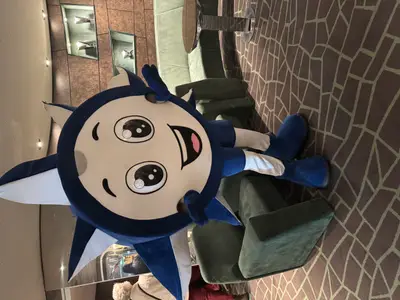 Das blaue, sternförmige Maskottchen Doremi posiert fröhlich in einer Lounge an Bord der MSC Preziosa.