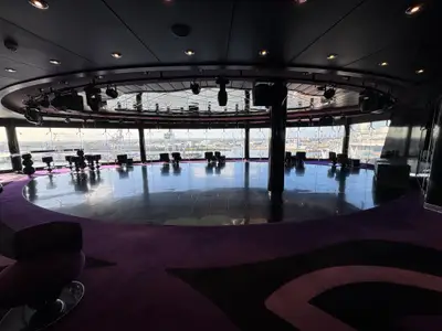 Blick in die moderne Panorama-Diskothek an Bord der MSC Preziosa mit glänzendem Tanzboden und Blick auf den Hafen.