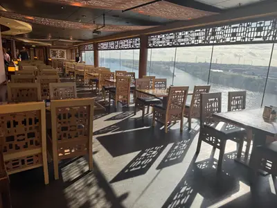 Das stilvolle asiatische Restaurant an Bord der MSC Preziosa bietet durch große Panoramafenster einen Ausblick auf einen Fluss.