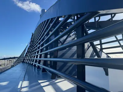 Eine Detailaufnahme der imposanten blauen Stahlkonstruktion auf dem Außendeck an Bord der MSC Preziosa vor blauem Himmel.