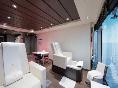 Blick in den modernen Nagelstudio-Bereich des MSC Aurea Spa an Bord der MSC Preziosa. Helle Sessel mit Fußbädern bieten Entspannung und Meerblick durch ein großes Panoramafenster. Weiße Handtücher liegen bereit.