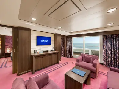 Ein luxuriöser Wohnbereich einer MSC Yacht Club Executive & Family Suite an Bord der MSC Preziosa mit lila Sofas, einem Flachbildfernseher und einem Fenster mit Meerblick.