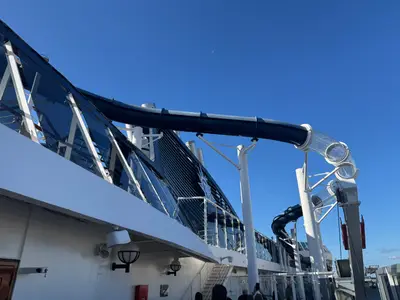 Blick auf die blaue und transparente Wasserrutsche Vertigo vor blauem Himmel an Bord der MSC Preziosa.