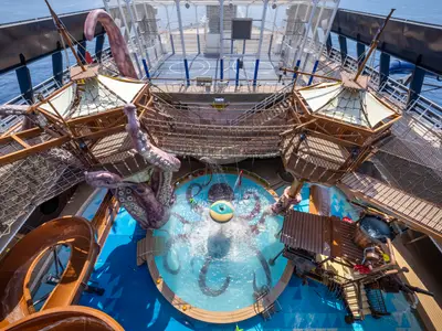 Blick von oben auf den actionreichen Pirates Cove Aquapark mit riesigem Kraken, Pool, Wasserrutschen und Abenteuerparcours an Bord der MSC Seascape.