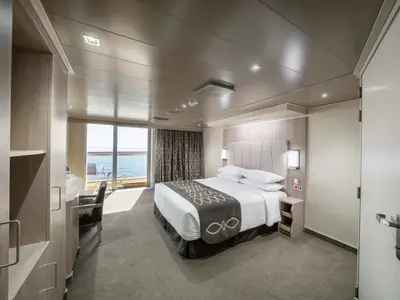 Eine geräumige, modern eingerichtete Balkonkabine an Bord der MSC Seashore mit Doppelbett, hellem Interieur und einem privaten Balkon mit Meerblick.