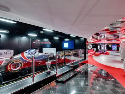 Der moderne Entertainmentbereich an Bord der MSC Seaside zeigt einen F1-Simulator und eine Bowlingbahn mit leuchtenden Pins. Im Hintergrund sind Arcade-Spiele sichtbar.