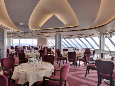 Elegantes Restaurant im MSC Yacht Club an Bord der MSC Seaside mit vielen Tischen, Blick auf das Meer und stilvoller Einrichtung.