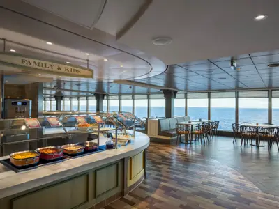 Der helle "Family & Kids" Buffetbereich an Bord der MSC Seaside bietet vielfältige Speisen in Chafing Dishes und Sitzgelegenheiten am Fenster mit Meerblick.