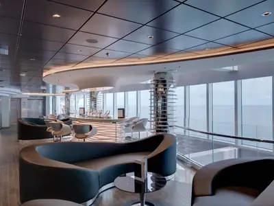 Die stilvolle Champagne Bar an Bord der MSC Seaview. Der Innenraum mit geschwungenen Theken und dunklen Sitzbänken blickt durch große Fenster auf das offene Meer.