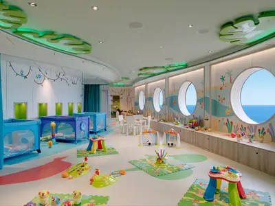Heller Baby Club Chicco an Bord der MSC Seaview mit Spielmatten, Spielzeugen, Babybetten und runden Bullaugen mit Meerblick.