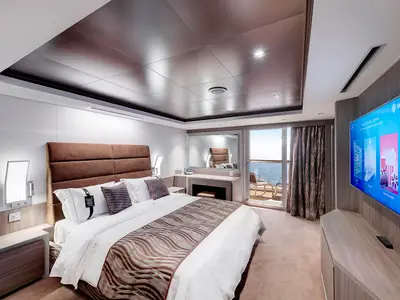 Balkonsuite an Bord der MSC Seaview. Doppelbett, TV, Schminktisch und Meerblick vom Balkon. Elegantes Design mit hellen Hölzern und moderner Beleuchtung. Keine Personen.