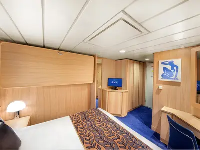 MSC Sinfonia Aussenkabine: Doppelbett, Schreibtisch, TV, Kunstbild an Holzwand und hochgeklapptes Pullman-Bett.