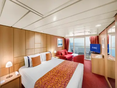 Helle Balkonkabine der MSC Sinfonia. Sie zeigt ein Doppelbett, ein rotes Sofa, einen Fernseher und einen Balkon mit Meerblick. Die Einrichtung besteht aus hellen Holzmöbeln und warmen Farbakzenten.