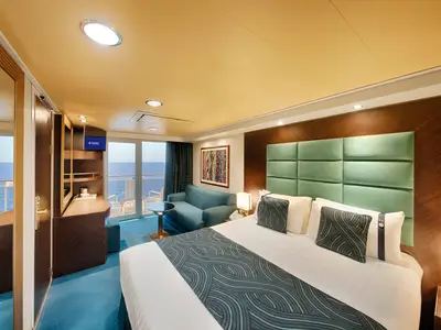 Geräumige Balkonkabine an Bord der MSC Splendida mit Blick auf das Meer. Zu sehen sind ein Doppelbett, Sofa, TV und Balkon. Das Zimmer ist modern eingerichtet.