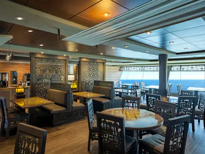 Panoramaansicht des hellen Buffetrestaurants an Bord der MSC Splendida. Sitzbereiche, Tische und ein Getränkebuffet mit weitem Meerblick.