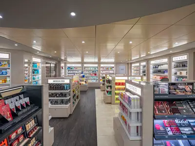 Ein hell beleuchteter Duty-Free-Shop mit Regalen voller Kosmetikprodukte und Parfüms von Marken wie Gucci und Lancôme an Bord der MSC Splendida.