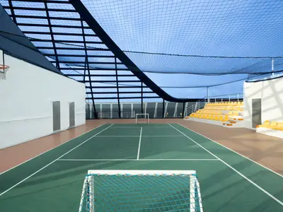 MSC Splendida: Die MSC Arena, ein grüner überdachter Sportplatz. Mit weissen Linien, Basketballkorb, Fussballtor und gelben Tribünensitzen. Ein Schutznetz spannt sich über die Anlage.
