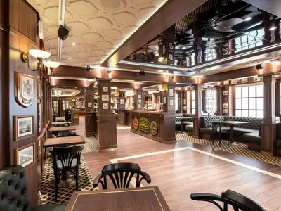 Das elegant eingerichtete Pub "Masters of the Sea" an Bord der MSC Virtuosa. Der Raum ist mit dunklen Holzpaneelen, bequemen Ledersitzbänken und einer grossen Theke gestaltet.