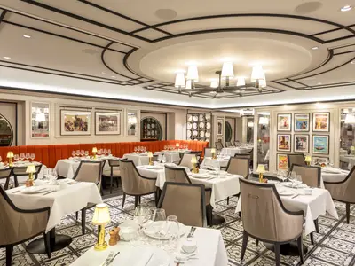 Elegantes Indochine Restaurant an Bord der MSC Virtuosa mit gedeckten Tischen, orangefarbenen Bänken und stilvoller Kunst.