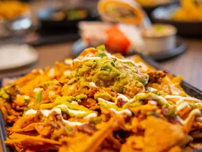Appetitliche Nachos mit Guacamole, Sour Cream, Tomaten und Zwiebeln, serviert in einem Spezialitätenrestaurant an Bord der MSC Virtuosa.