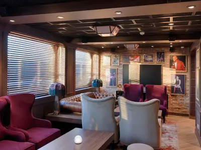 Gemuetliche Bar & Lounge an Bord der MSC World America mit Sesseln, Sofas, Fenstern und Kunst an der Backsteinwand.