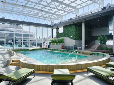 Der überdachte Botanic Garden Pool an Bord der MSC World America, mit einem grossen Schwimmbecken, Liegen und einer Lounge-Ecke. Grüne Pflanzenwände und eine Glaskuppel prägen den hellen Raum, mit Blick auf das Aussendeck.