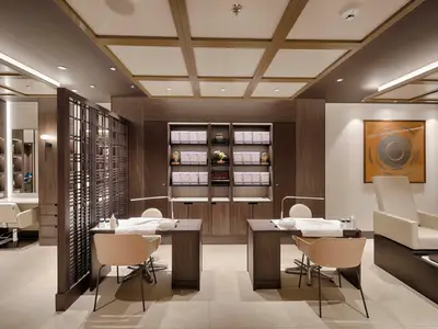 Ein eleganter und modern gestalteter Spa-Bereich an Bord der MSC World America. Im Vordergrund sind zwei Nagelstudio-Tische mit Stühlen zu sehen. Im Hintergrund befinden sich Regale mit Pflegeprodukten und eine Pediküre-Station. Die Einrichtung ist in warmen Holztönen gehalten mit heller Beleuchtung.