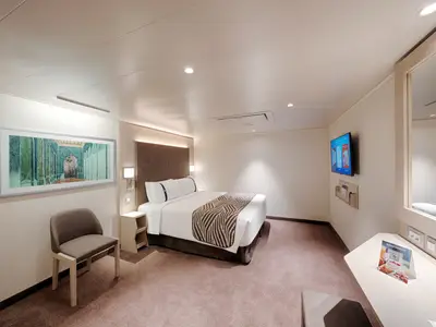 Helle, barrierefreie Innenkabine der MSC World Asia. Doppelbett, Nachttische, Wandleuchten, ein abstraktes Kunstwerk und Flachbildfernseher sind sichtbar. Modern und funktional eingerichtet.