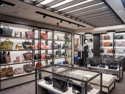 An Bord der MSC World Asia: Ein eleganter Shop mit beleuchteten Regalen voller luxuriöser Handtaschen und Accessoires. Eine Schaufensterpuppe ist sichtbar.
