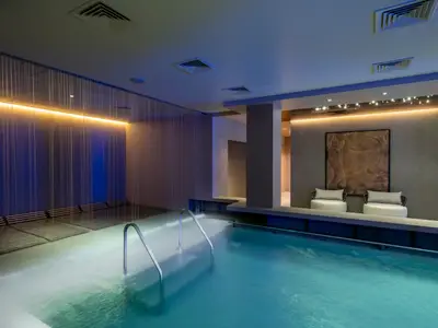 Der ruhige Spa-Poolbereich an Bord der MSC World Asia. Er verfügt über einen beleuchteten Innenpool, einen Wasservorhang und eine Buddha-Skulptur mit Sitzgelegenheiten.